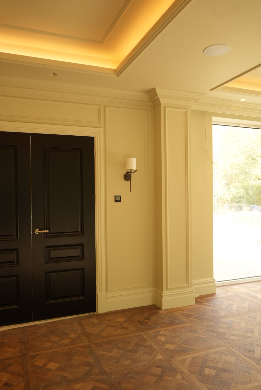 Panelled walls, dark-stained doors and a bronze wall light