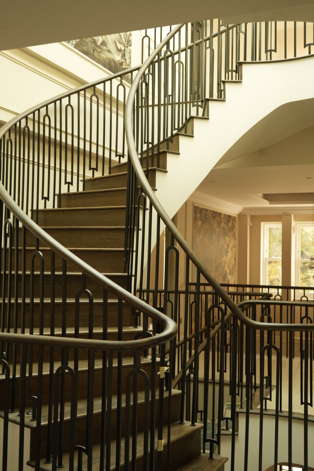 Oak treads and the bronze balustrade, climbing past the windows
