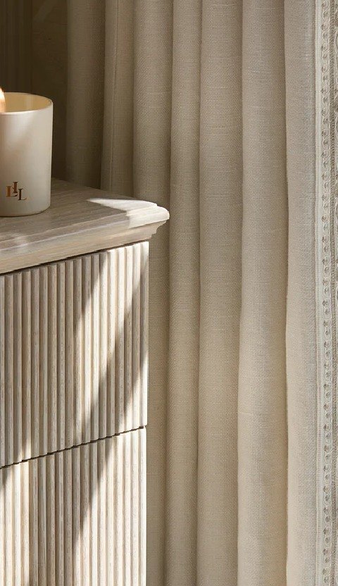Fluted oak drawers beside linen drapery