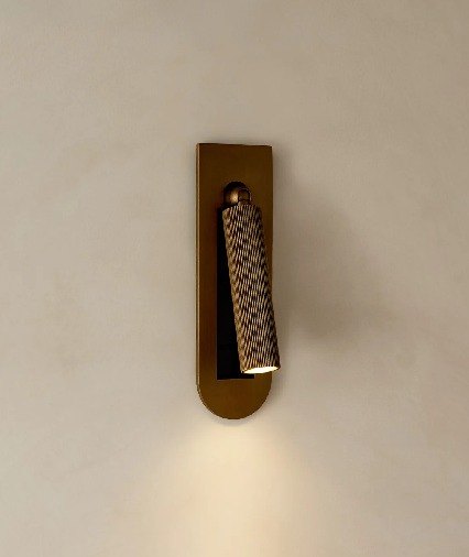 A bronze reading light on a plaster wall