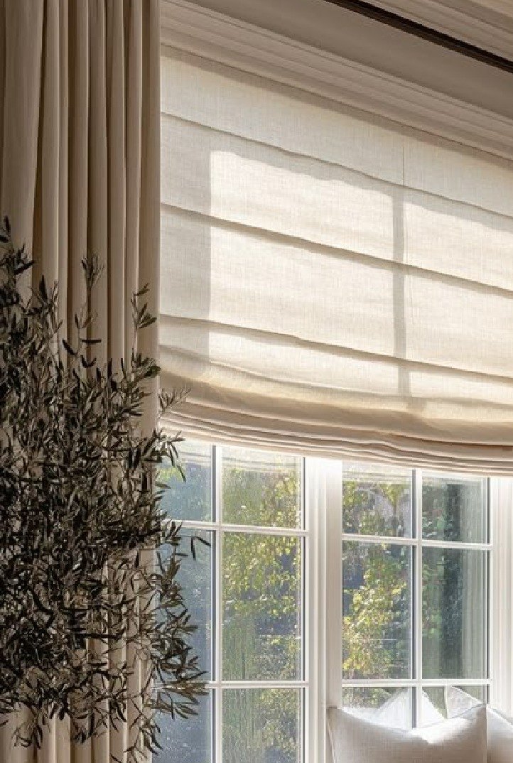 Unlined linen roman blind and drapery at a bay window
