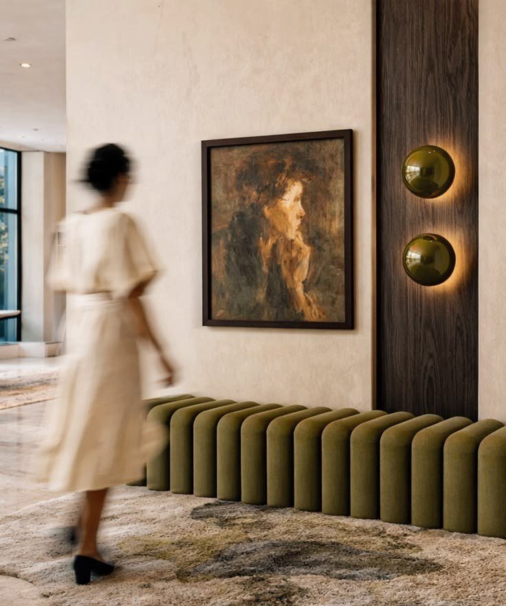 Plaster walls, a single portrait and a fluted bench in olive velvet
