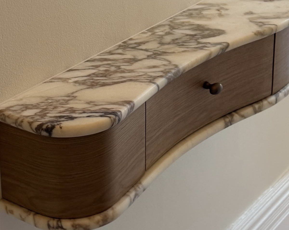 A curved console in walnut and veined marble