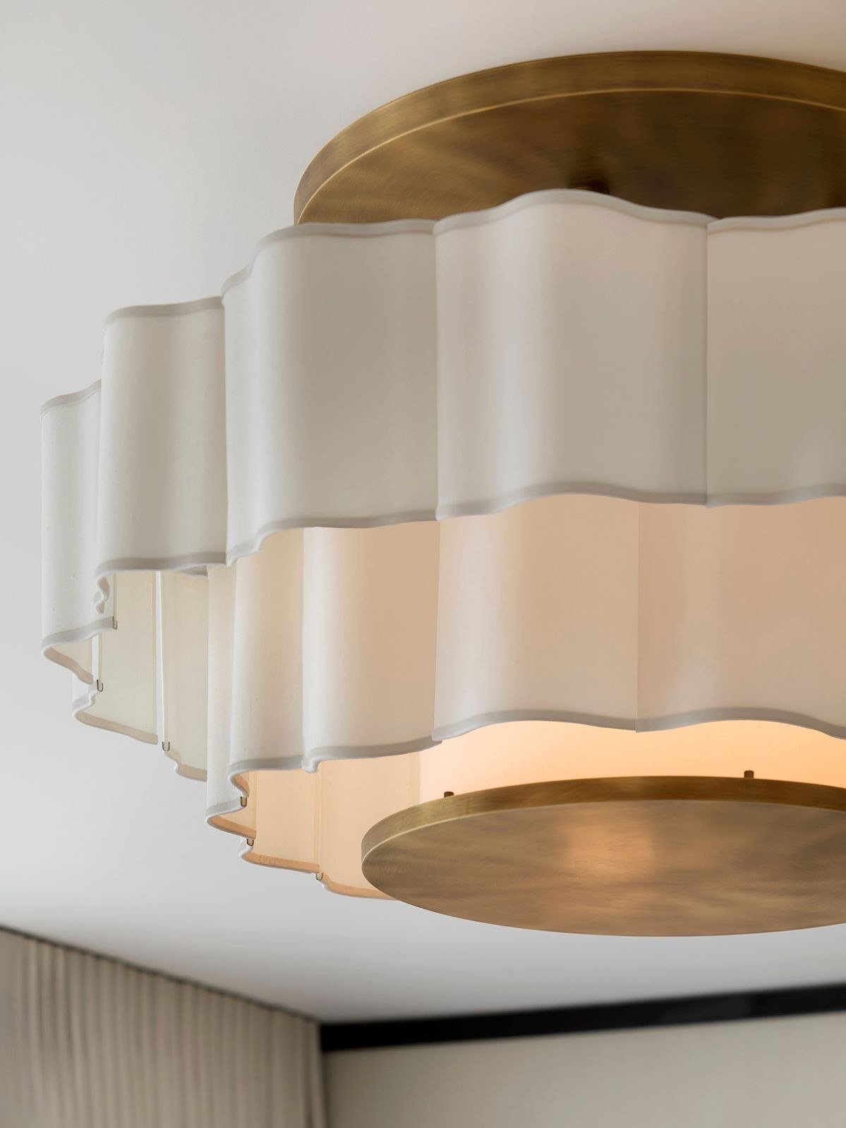 A scalloped silk shade on aged brass