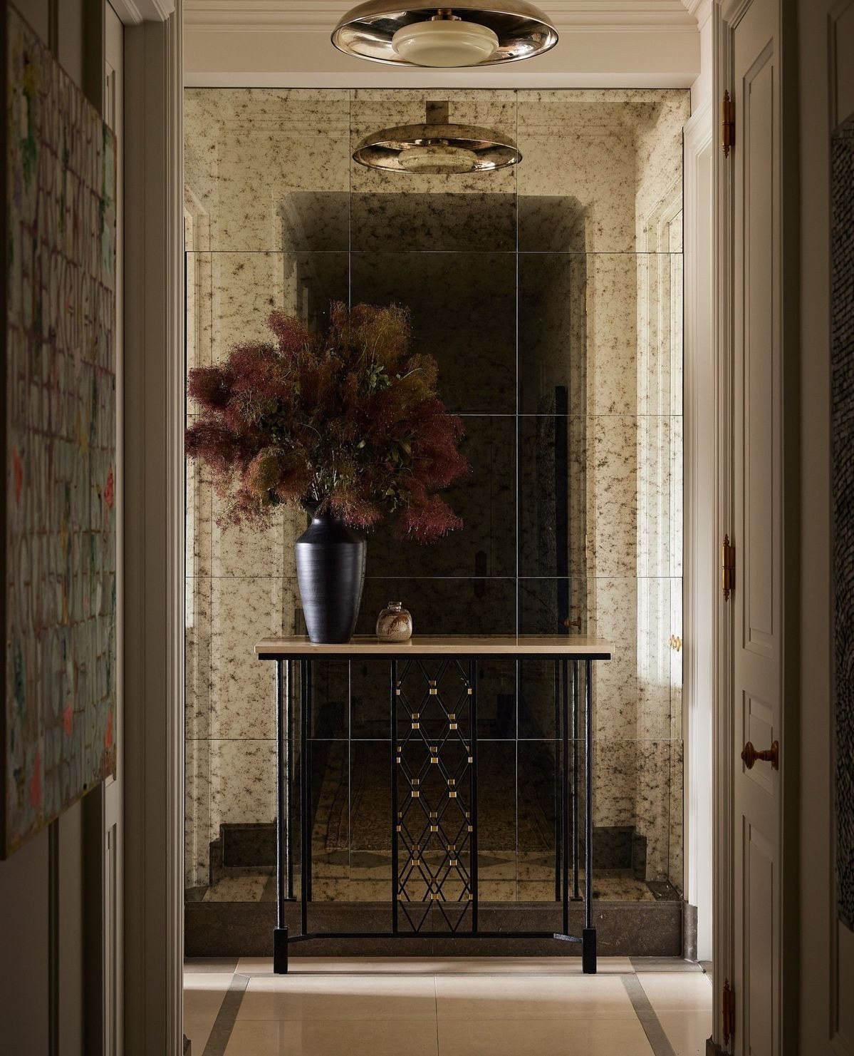 A mirrored wall holds the console and a single arrangement