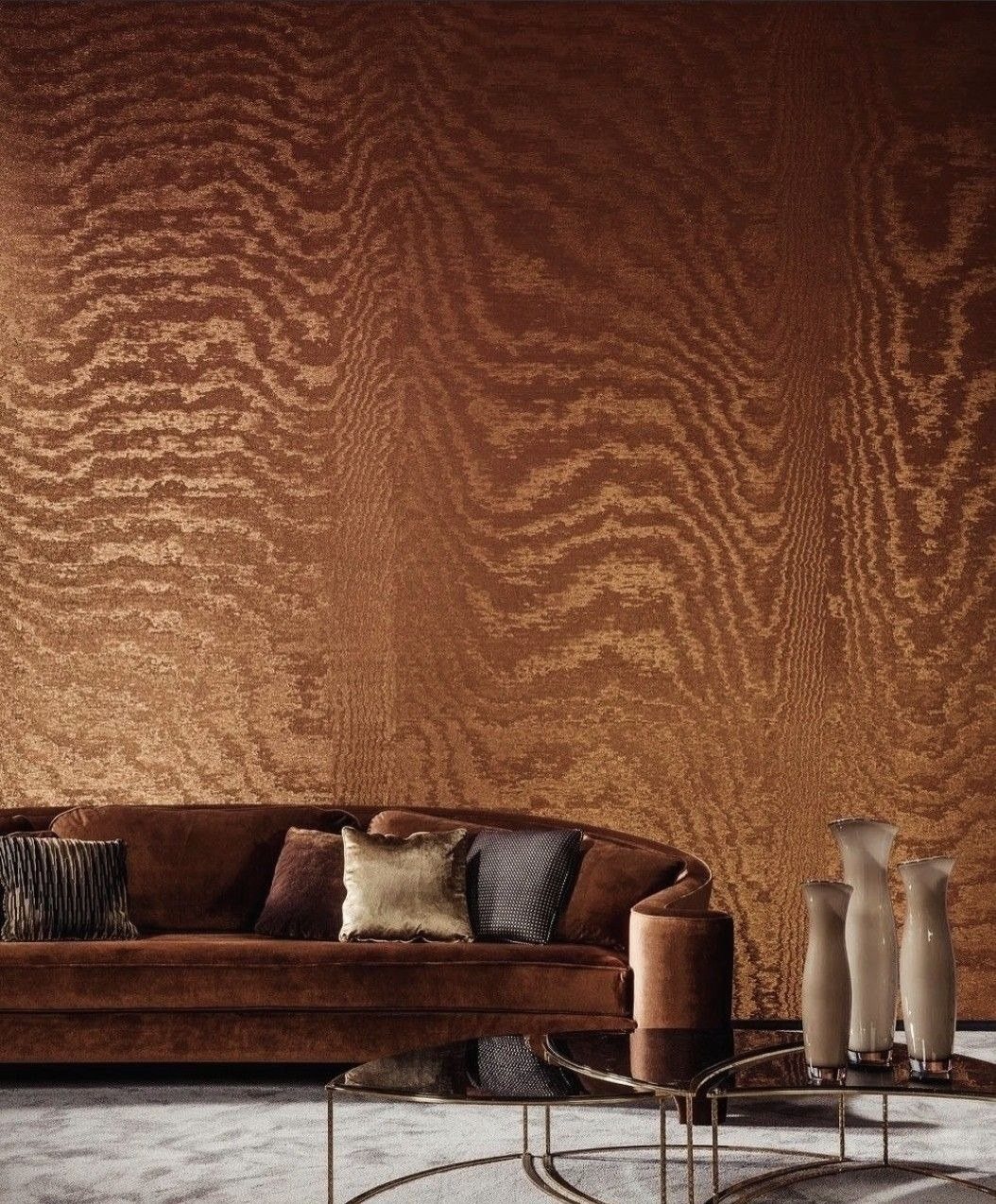 A moiré wall behind a curved velvet sofa
