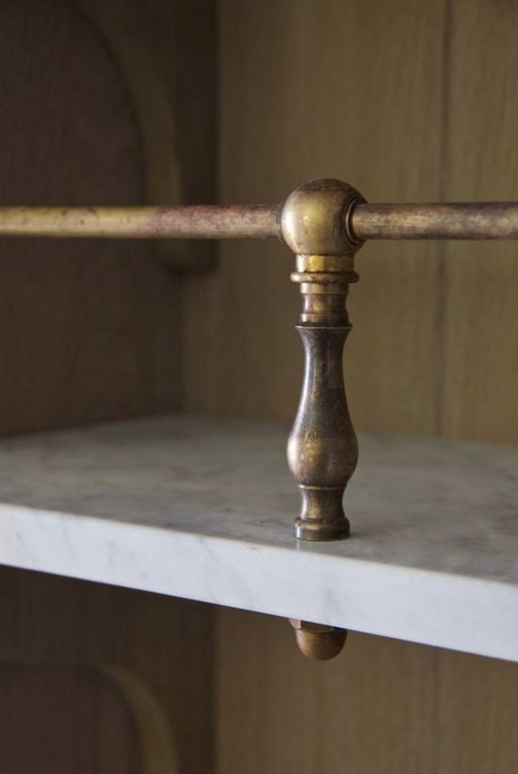 An aged brass gallery rail on marble