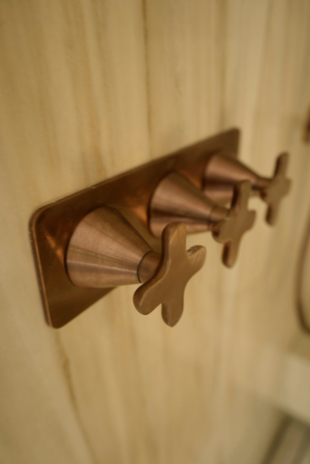 Bronze shower valves set in honed stone